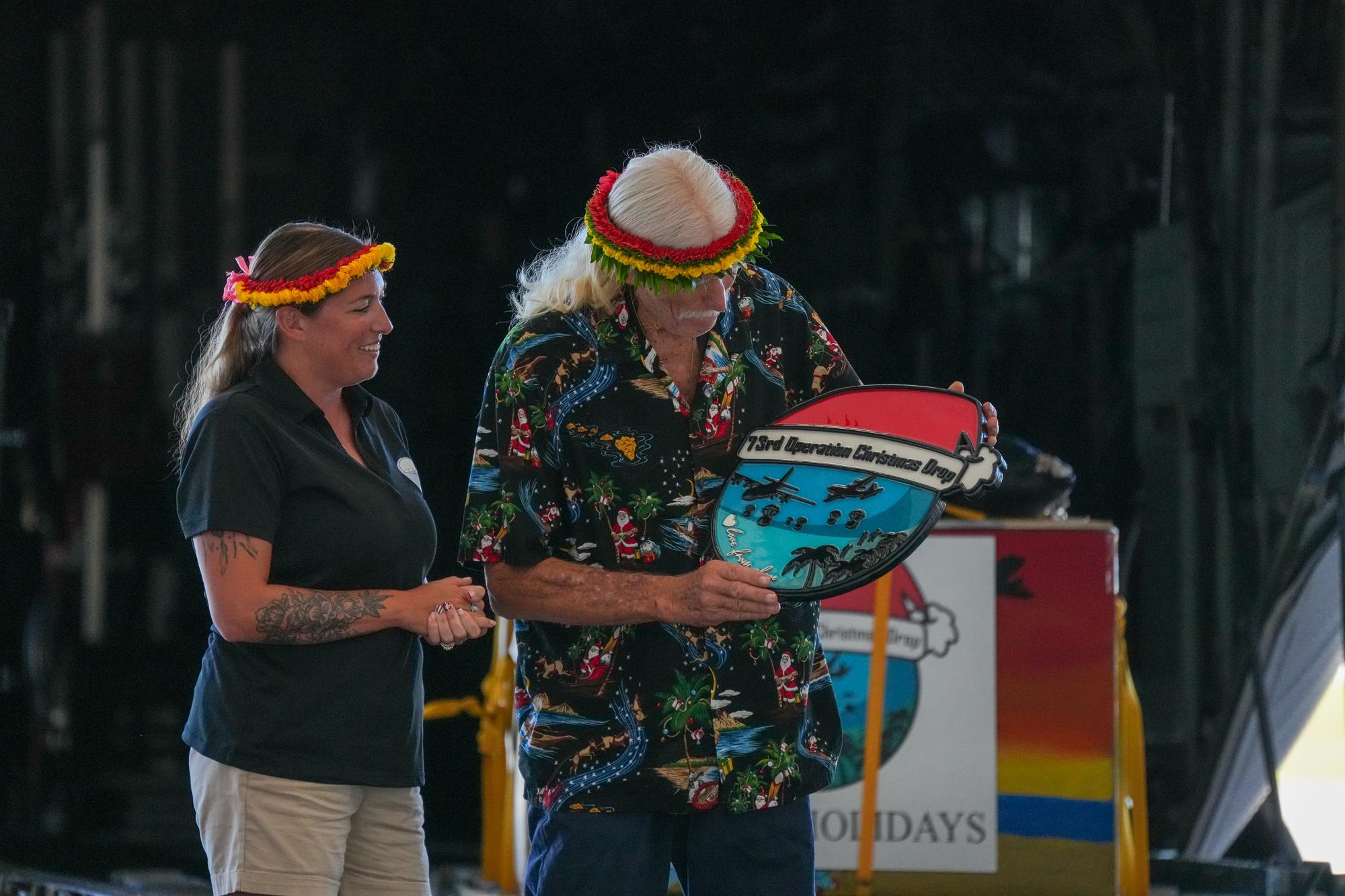 (From left) Master Sgt. Theresa Buck, committee president, and Brother Bruce Best, spokesperson, both from Operation Christmas Drop. Buck gifted Bruce a token of appreciation for his efforts and role in OCD. Photo by Skyler Obispo. 