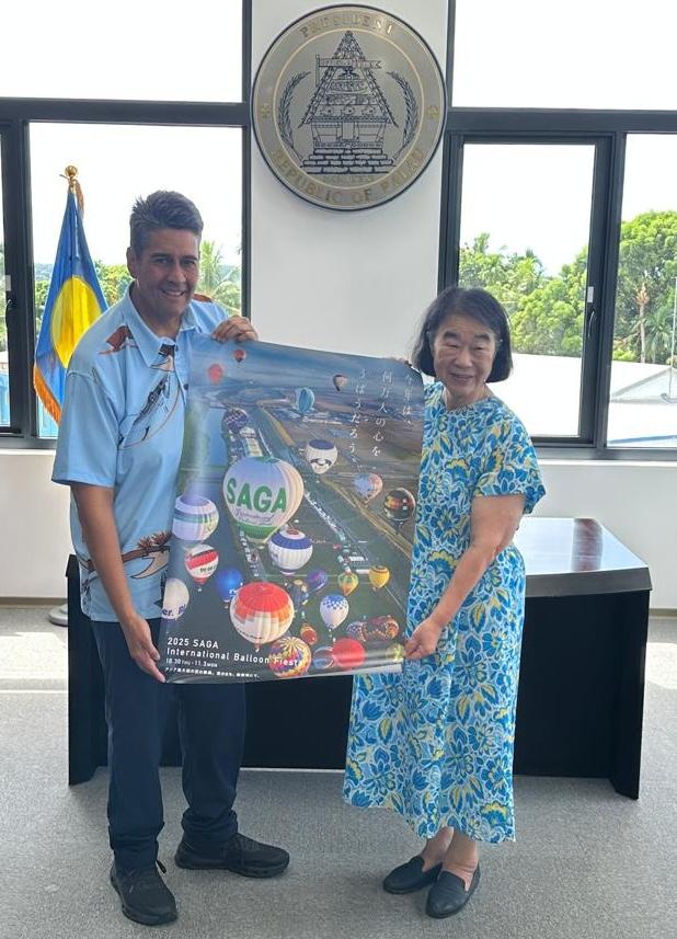 Atsuko Tateshita, representing non-profit organization Ai Mirai, presented a poster of the upcoming 2025 Saga International Balloon Fiesta to President Surangel S. Whipps, Jr. 